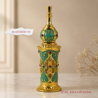 An ornate perfume bottle with a turquoise enamel body, intricate gold filigree patterns, and small red gemstone accents, displayed on a light marble surface with a beige background.