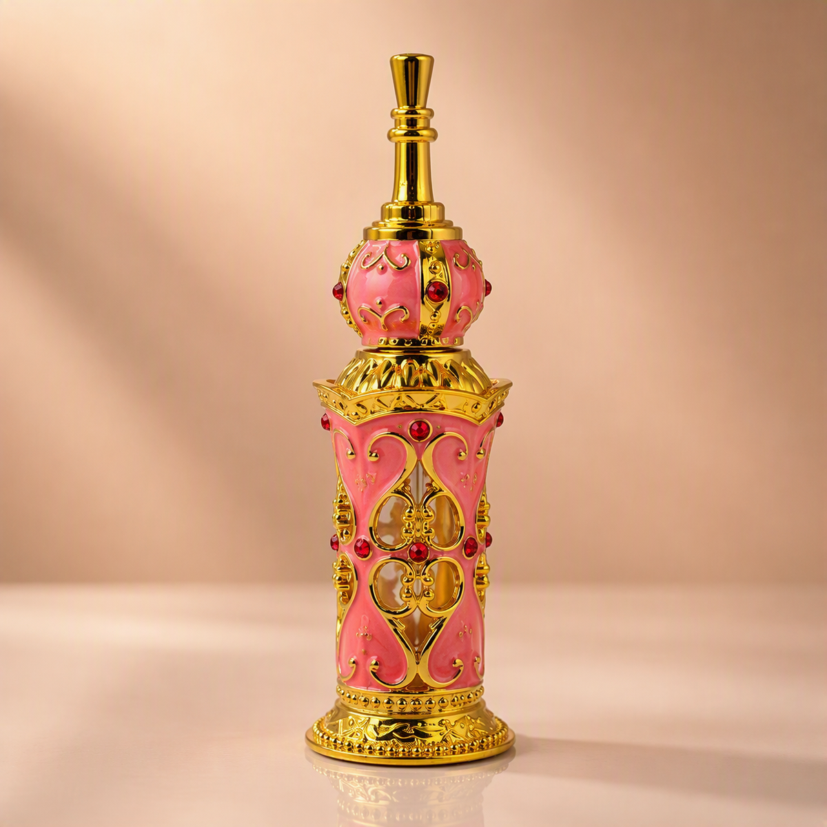 An ornate pink and gold perfume bottle with decorative filigree and red gem accents, centered on a warm beige background.