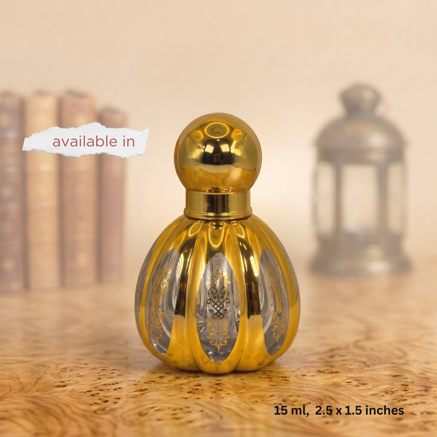 A small decorative perfume bottle with a shiny gold metallic finish and a rounded spherical cap, shown on a wooden surface with a softly blurred background. Text on the image notes it is available in 15 ml, 2.
