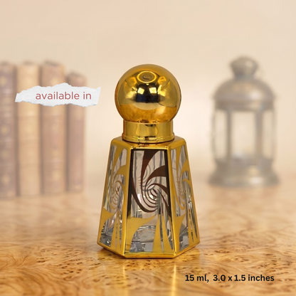 A small decorative perfume bottle with a shiny gold spherical cap and a faceted gold base featuring mirrored geometric patterns, shown on a wooden surface with a softly blurred background. Text overlays read 'available in' and '15 ml, 3.